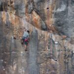 A man climbing a cliff face at Cala Bota Majorca